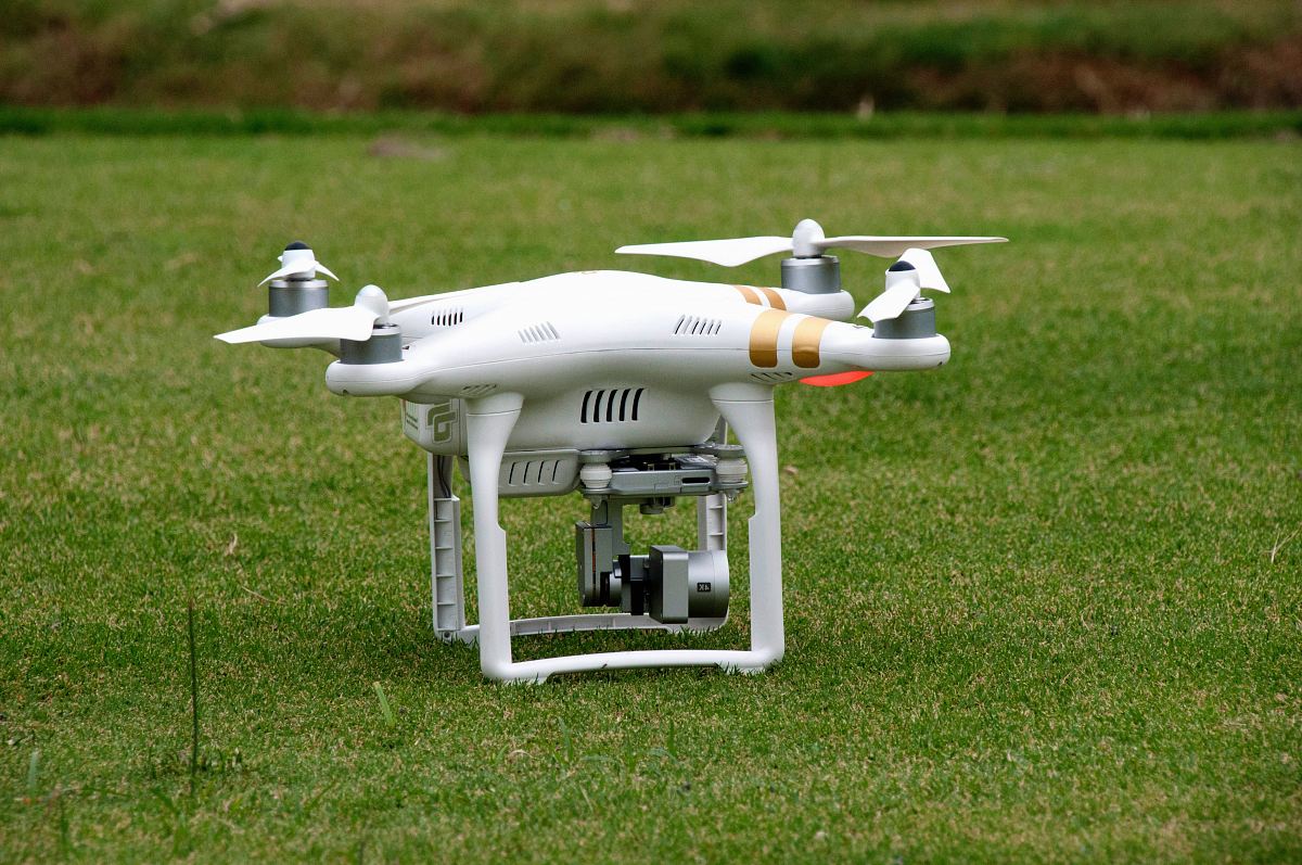 white quadcopter on lawn